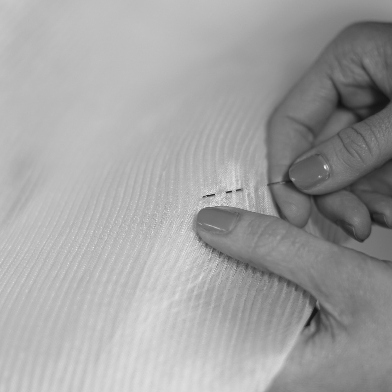 Needle being pushed through light fabric